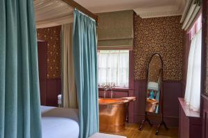 a bedroom with a tub and a sink and a window at The Mitre, Hampton Court in Kingston upon Thames +37 photos