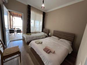 a bedroom with two beds and a table and chairs at Guest House Aisi in Sighnaghi