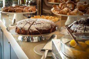 a table with several cakes and pastries on plates at The Ziba Hotel & Spa in Peschiera del Garda