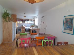 una cucina con un tavolo di legno e sedie colorate di Auberge du Champ Commun ad Augan