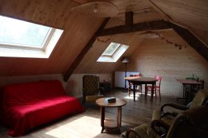 un soggiorno con divano rosso in mansarda di Auberge du Champ Commun ad Augan Altre 22 foto