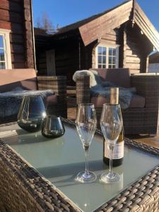 a table with two wine glasses and a bottle of wine at Cabin with Porsche to rent in Sogndal