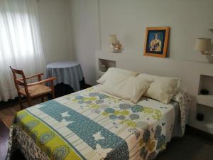 a bedroom with a bed with a quilt on it at O Piso dos Avós in A Guarda