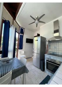 a kitchen with a table and a ceiling fan at Villa Elena Riva Marina in Specchiolla 