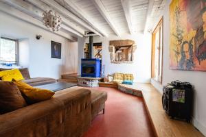 a living room with a couch and a tv at La Trêve - Mas 12 personnes rénové avec Piscine in Saint-Julien-du-Serre