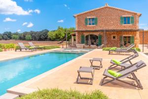 a villa with a swimming pool and lounge chairs at Son Catxo in Búger