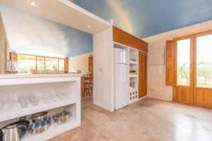 a kitchen with white cabinets and a blue ceiling at Can Jeroni Carrio in Cala Bona
