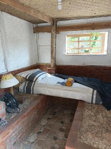 MalukにあるTiny Houseの窓のある部屋にある小さなベッド