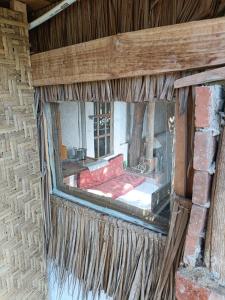 MalukにあるTiny Houseの赤いソファのある建物の古い窓
