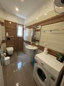 een badkamer met een wasmachine en een wastafel bij Seaside Apartmens Sarande in Sarandë