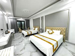 a hotel room with two beds and a sink at Đông Thắm Hotel in Diện Biên Phủ