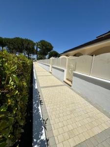 a walkway with a fence and plants on it at Giglio di Mare Apartments in Rossano +18 photos