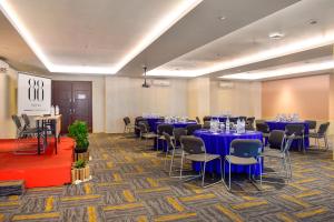 a conference room with blue tables and chairs at Hotel 88 Embong Malang Surabaya By WH in Surabaya