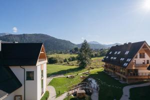 an aerial view of a house with mountains in the background at Polana Resort - LoftAffair Collection in Kościelisko +216 photos