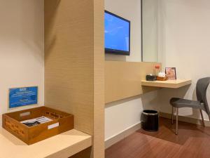 Una televisión o centro de entretenimiento en Hotel 88 Embong Malang Tunjungan Surabaya by WH - Breakfast with The Best View on The Highest Floor and Strategic Location in The City Center