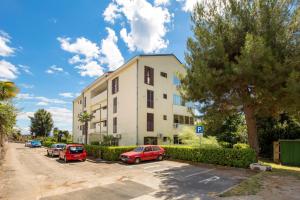a building with cars parked in a parking lot at Apartment Marko in Lovran