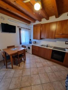 una cucina con un tavolo di legno e un tavolo e sedie di La Casa di Giorgia a Chioggia
