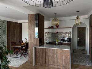 a kitchen with wooden cabinets and a dining room at Palastura Apartments in Ulcinj