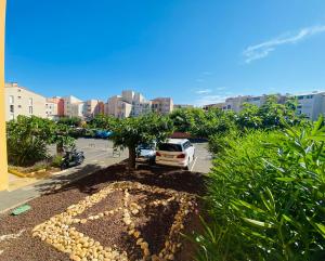 ein auf einem Parkplatz mit einem Baum geparktes Auto in der Unterkunft A 100m de la plage A3, Rez-de-chaussee in Cap d'Agde