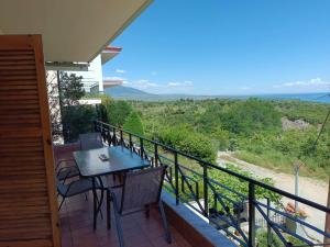 a balcony of a house with a table and chairs at Rainbow Castle Villa neos panteleimonas in Neos Panteleimonas