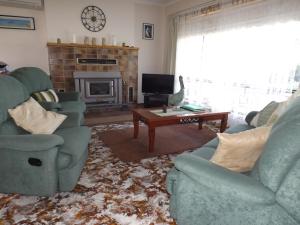 a living room with two chairs and a fireplace at Kirazz Holiday Homes in Kingscote