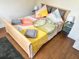 a large bed with colorful blankets and pillows on it at Renovated French Village Pavilion House - A Home for Your Next Holiday in Saint-Fraimbault