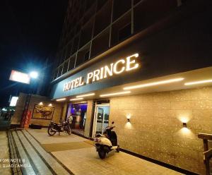 Ein Roller, der nachts vor einem Hoteleingang geparkt ist in der Unterkunft Hotel Prince in Guwahati