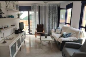 ein Wohnzimmer mit Sofa und Tisch in der Unterkunft Piso planta baja y gran patio con piscina comunitaria de alquiler temporal in Daimús