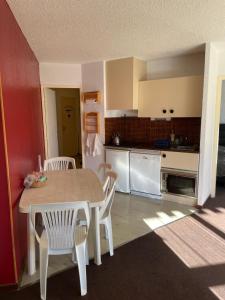 Una cocina con una mesa y sillas en una habitación. en T2 Praloup 1500, en Uvernet