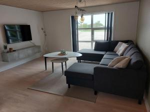a living room with a couch and a table at Vakantiewoning Denemarken in Års