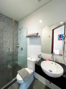 a bathroom with a toilet and a sink and a shower at Hotel 88 Embong Malang Surabaya By WH in Surabaya