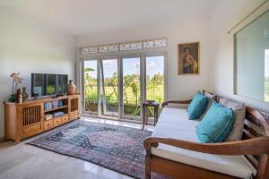 un salon avec un canapé et une télévision dans l'établissement Villa Tau, à Tegalalang