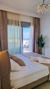 a bedroom with a large bed with a window at Sol Mate Luxury Villa in Nikiti