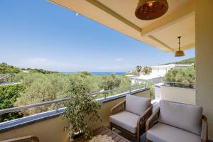 a balcony with two chairs and a view of the ocean at President Bungalows and Apartments in Utjeha