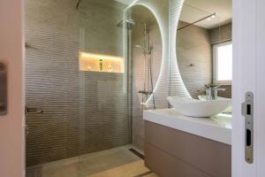 a bathroom with a sink and a glass shower at President Bungalows and Apartments in Utjeha