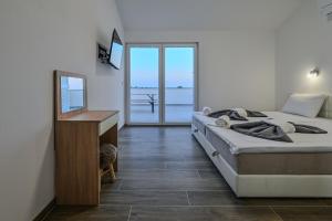 Un dormitorio con una cama y un escritorio con espejo. en Villa Joanna - hidden oasis with pool, gym & garrage, en Novalja 29 fotos más