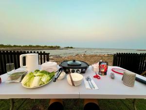 a white table with a grill and vegetables on it at Cape House in Ban Bang Kaeo