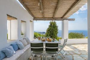 a dining room with a couch and a table and chairs at Amazing Sea View, Mykonos Cycladic Villa, Priv Pool in Mýkonos City