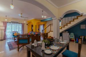 a living room with a table and a staircase at TreeHouse Blue Hotel & Villas in Colva