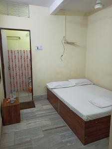 a bedroom with two twin beds and a mirror at Hotel Alka in Varanasi