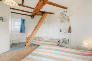 a white room with a ladder and a bed at Ancien moulin à vent du 19e siècle in Cherrueix