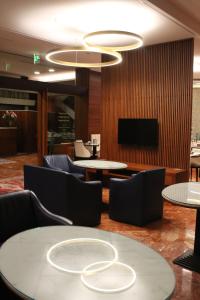 a lobby with tables and chairs and a flat screen tv at Hotel Europa in Verona