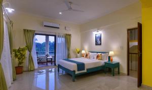a bedroom with a bed and a large window at TreeHouse Blue Hotel & Villas in Colva +40 photos