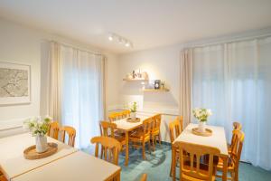 a dining room with two tables and chairs at Waldhotel Schöneiche -Self Check-In- in Schöneiche