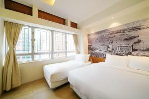 duas camas num quarto com um quadro na parede em The Salvation Army - Booth Lodge em Hong Kong