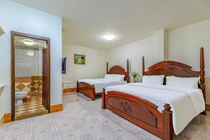 a hotel room with two beds and a bathroom at 万象莉莉酒店 Lilyhotel in Vientiane