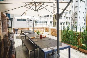 uma mesa e cadeiras em uma varanda com um guarda-chuva em The Salvation Army - Booth Lodge em Hong Kong
