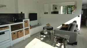 a living room with a couch and a tv at Casa Louise - Piscine et jacuzzi privatifs in Sainte-Maxime +1 photo