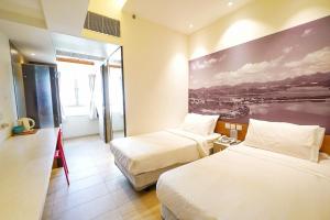 um quarto de hotel com duas camas e uma pintura na parede em The Salvation Army - Booth Lodge em Hong Kong