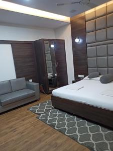 a bedroom with a large bed and a couch at Hotel Alka in Varanasi